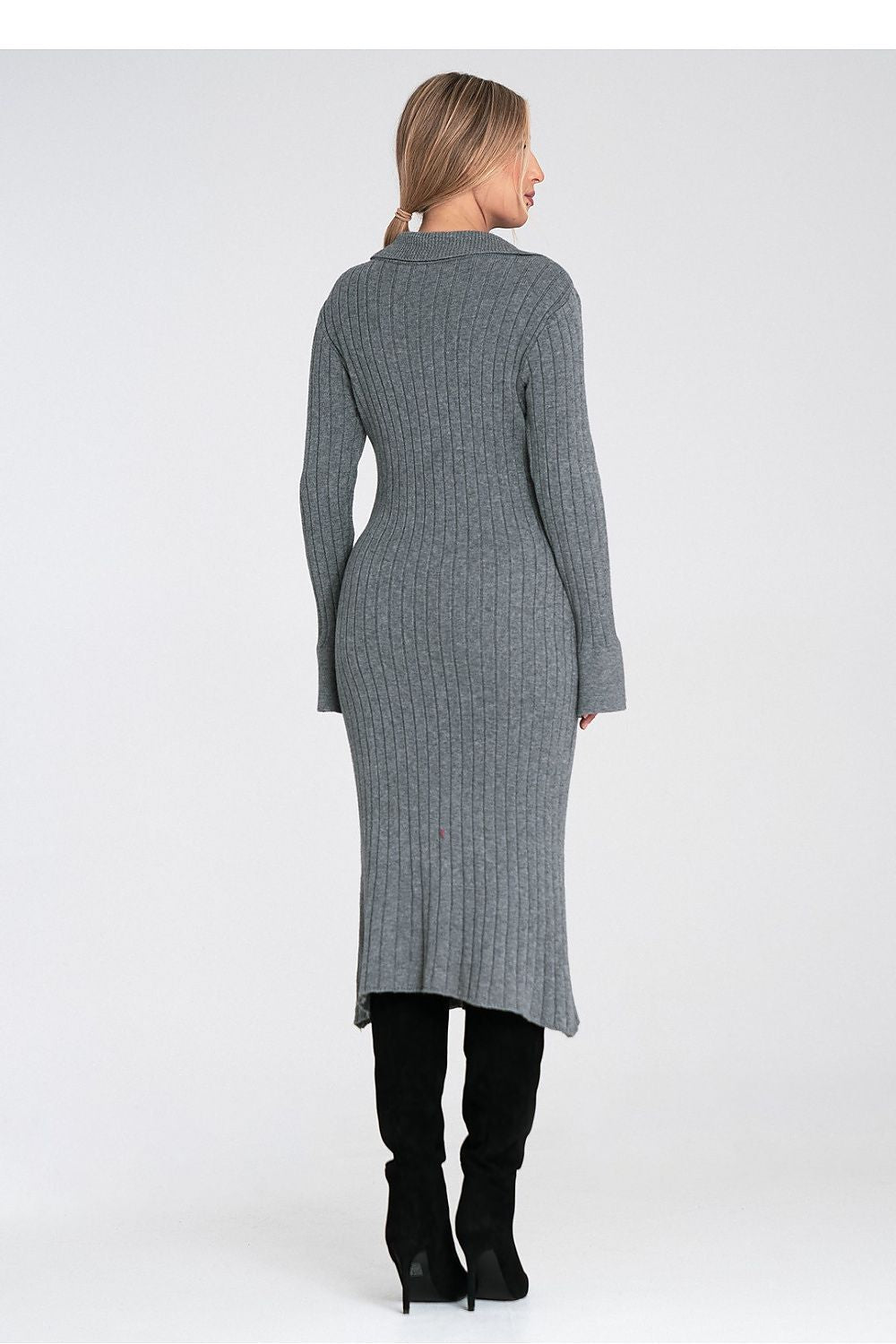 Woman wearing a long gray ribbed dress on a white background
