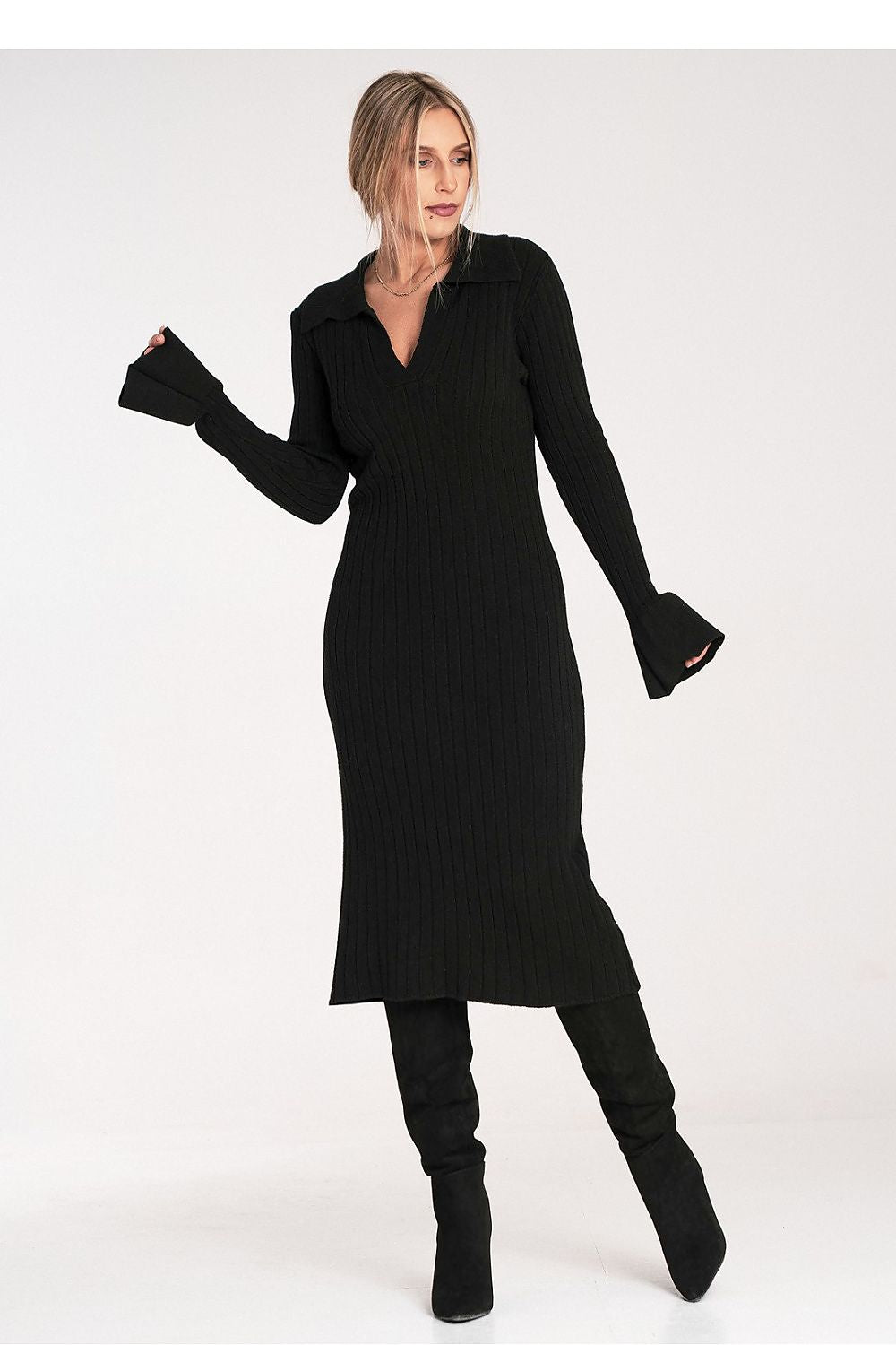 Woman wearing a black dress and black knee-high boots on a white background