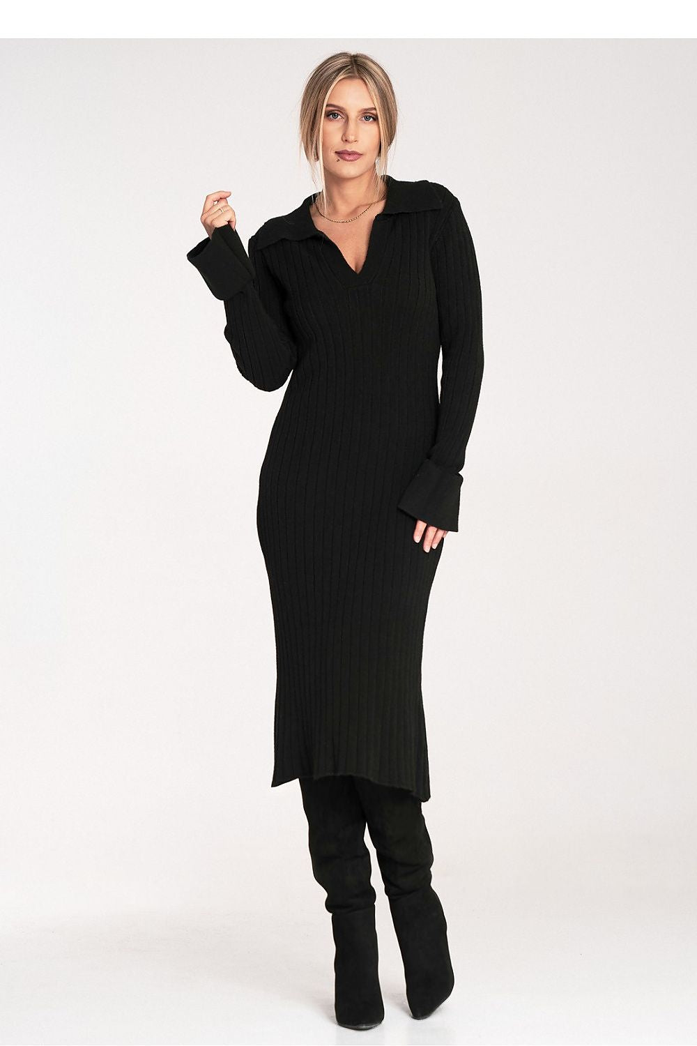 Woman wearing a black dress with long sleeves and a high-low hemline on a white background