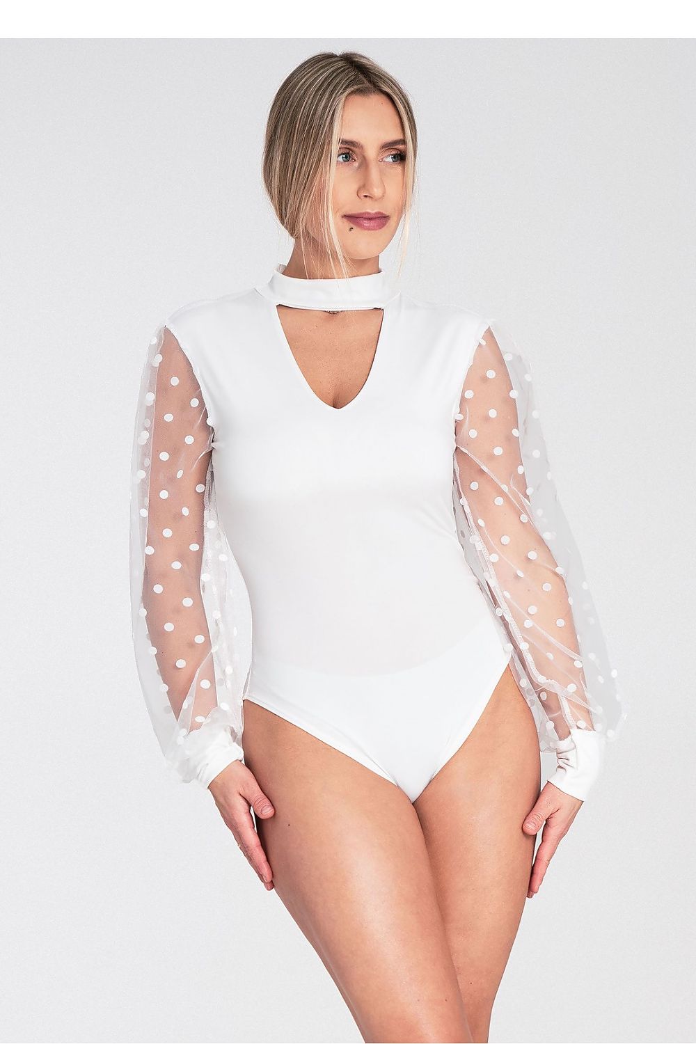 White bodysuit with sheer sleeves featuring polka dots on a white background