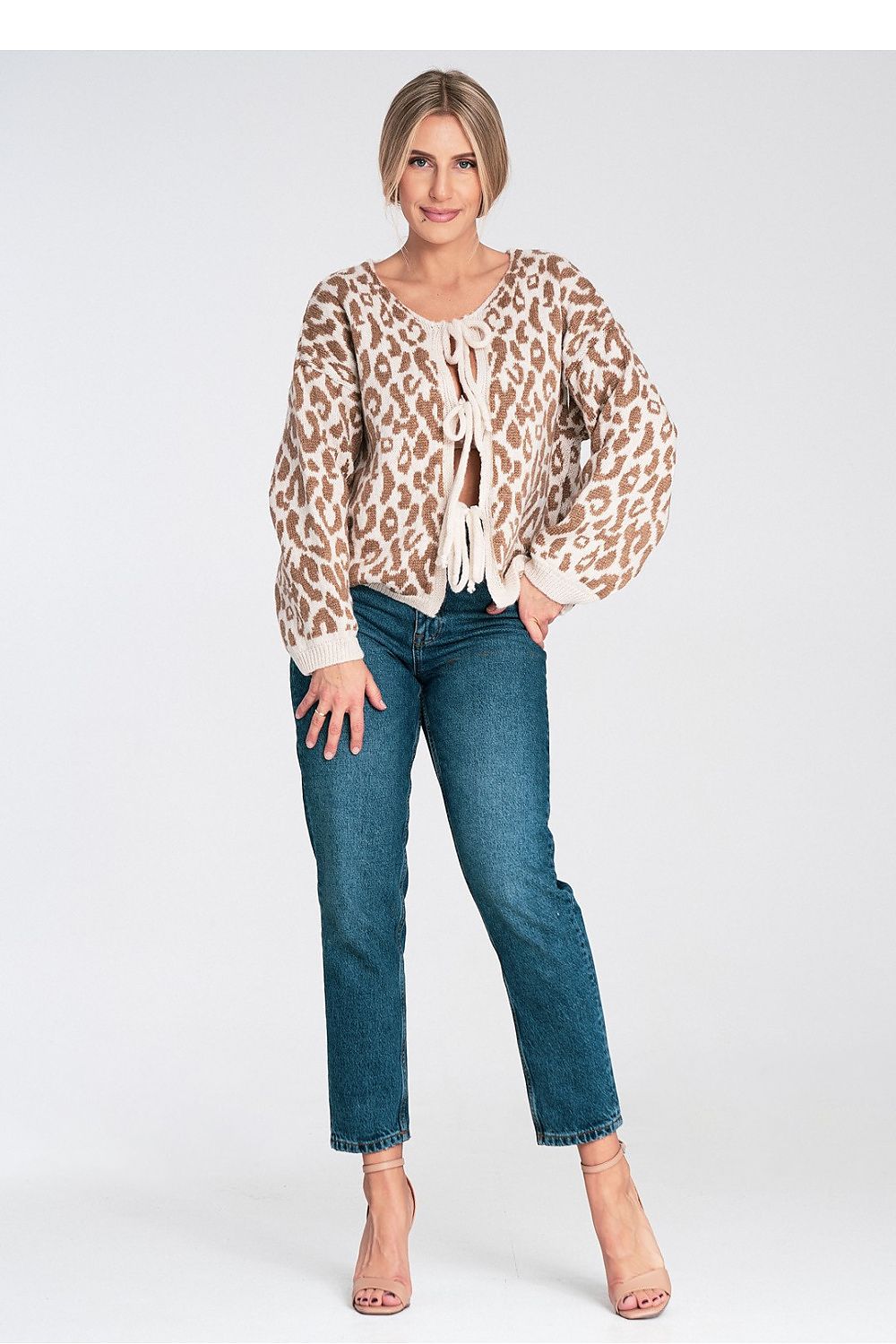 Woman wearing a leopard print blouse and blue jeans on a white background