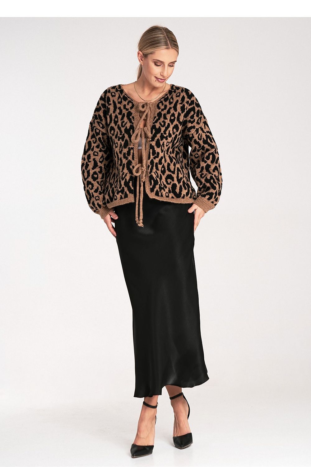 Woman wearing a leopard print top and black skirt on a white background