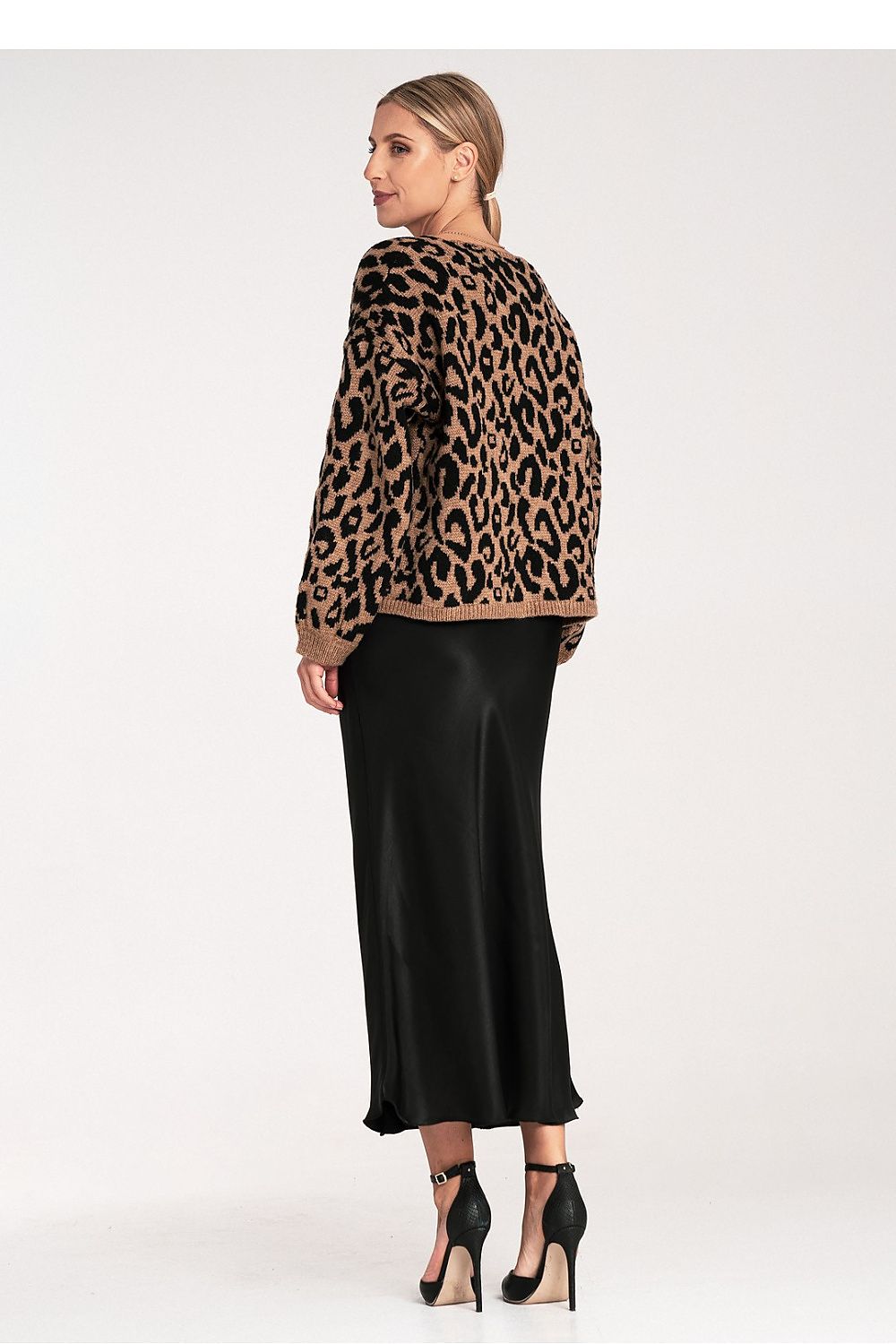 Woman wearing a leopard print jacket and black skirt on a white background