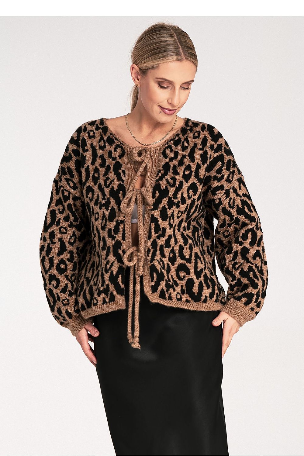 Woman wearing a leopard print cardigan on a white background