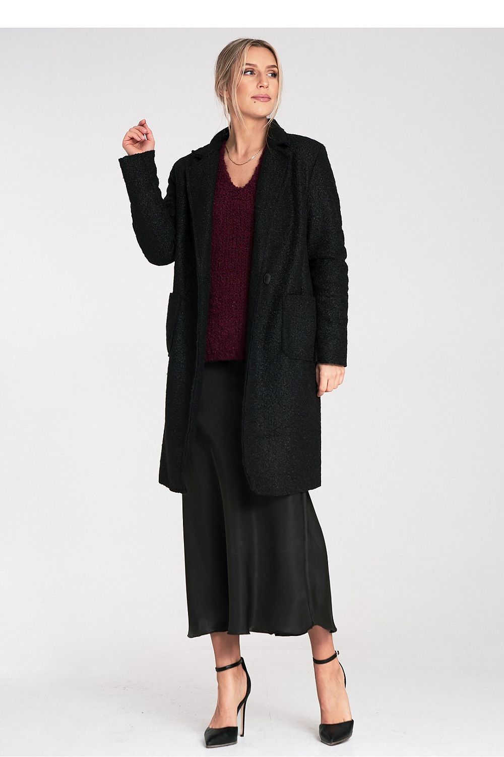 Woman wearing a black coat and skirt set on a white background