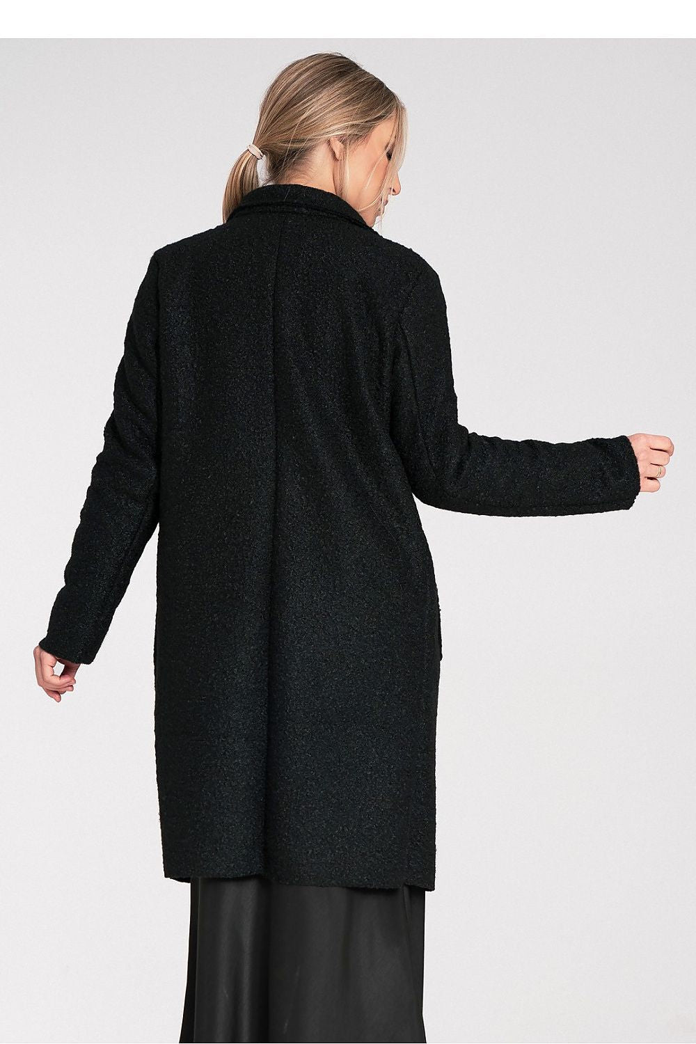 Woman wearing a black coat on a white background