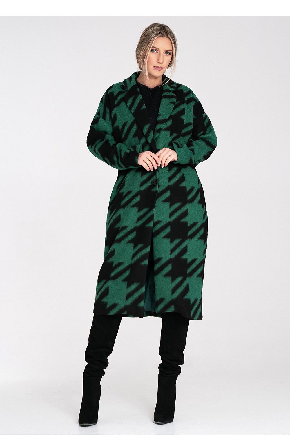 Woman wearing a green and black patterned dress on a white background