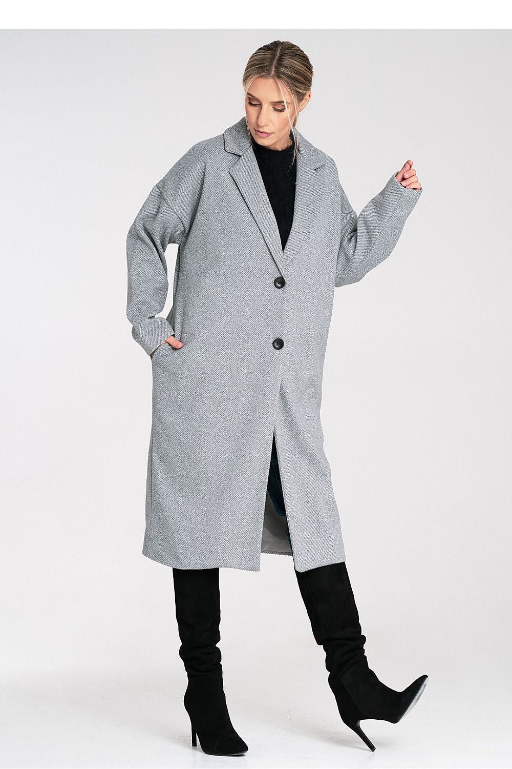 Woman wearing a gray coat and black boots on a white background