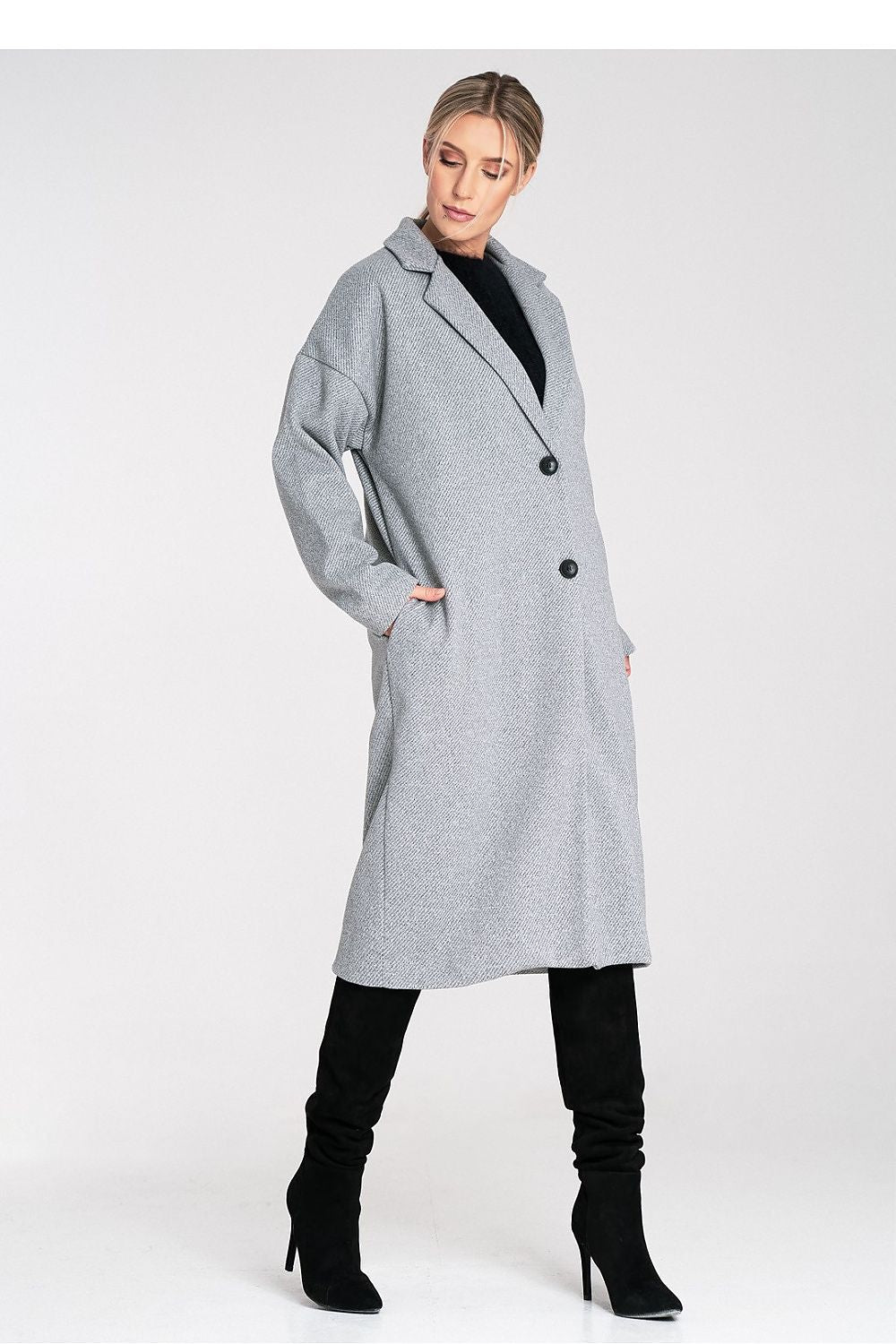 Woman wearing a gray coat with black boots on a white background