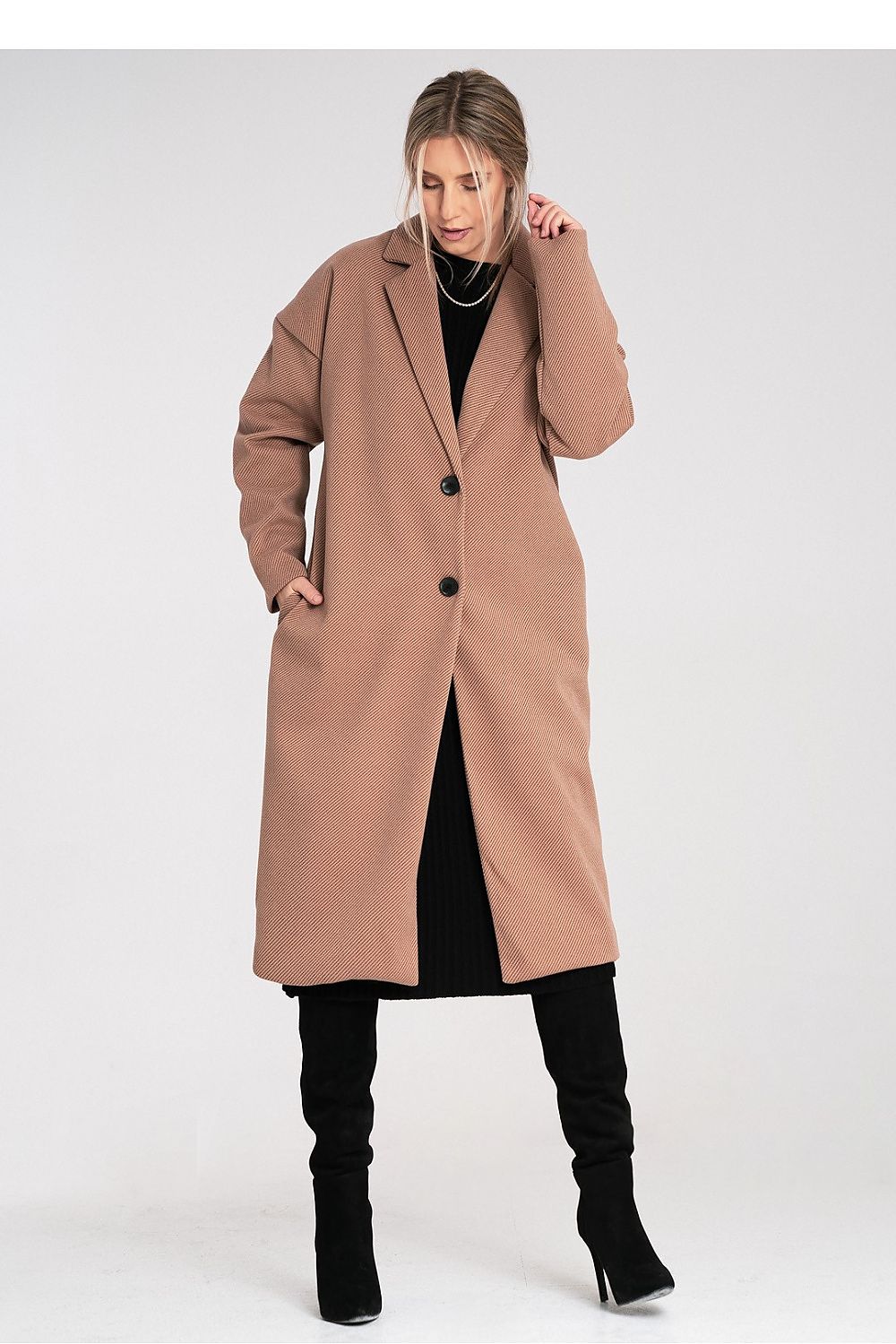 Woman wearing a long beige coat on a white background