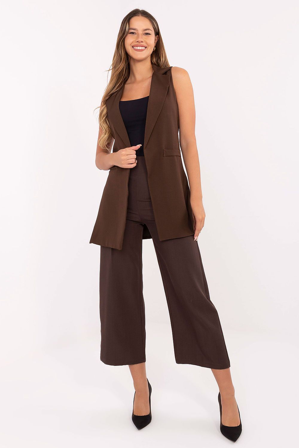 Woman wearing a brown vest and wide-leg pants on a white background