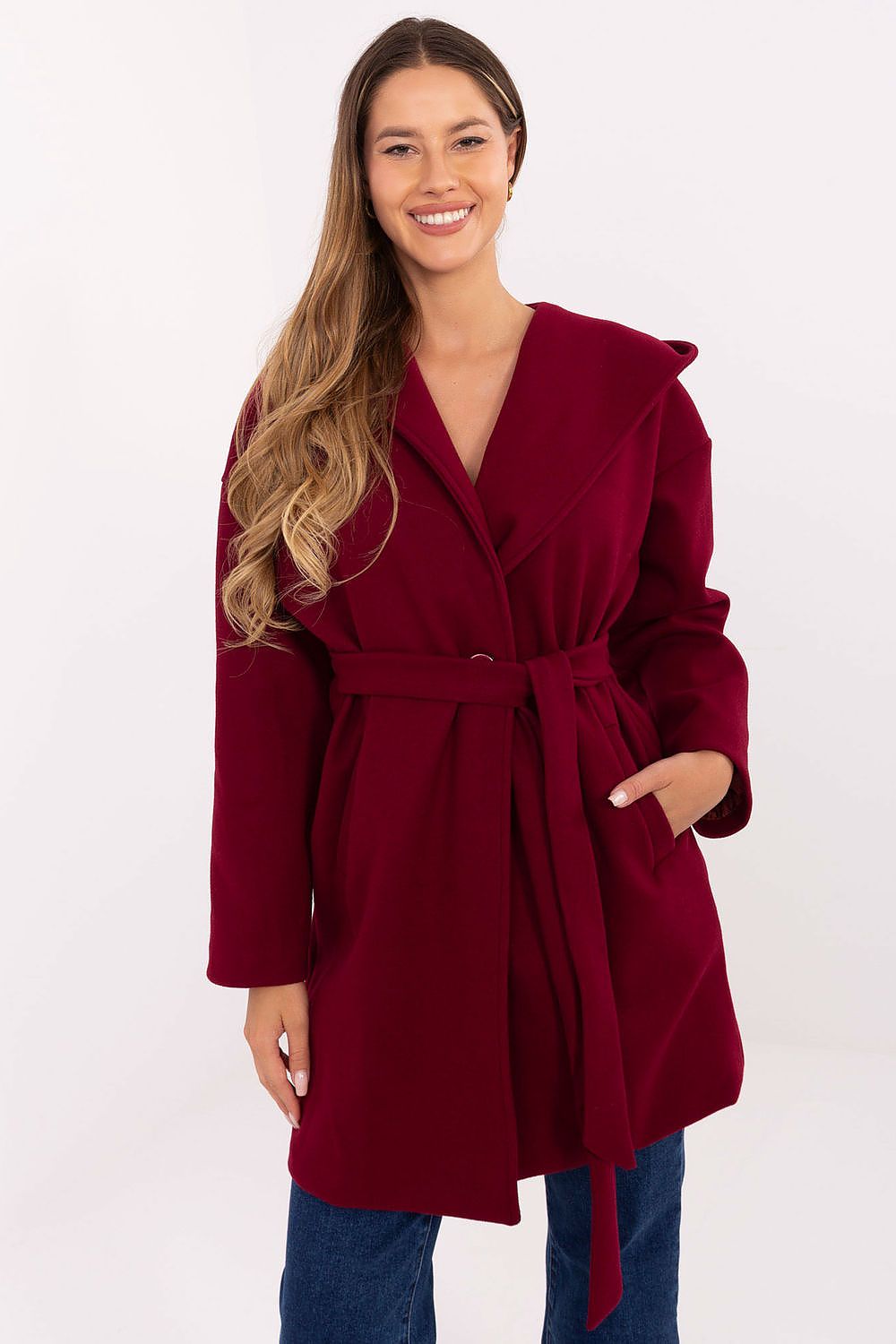 Front view of red hooded women’s belted coat with longline silhouette.