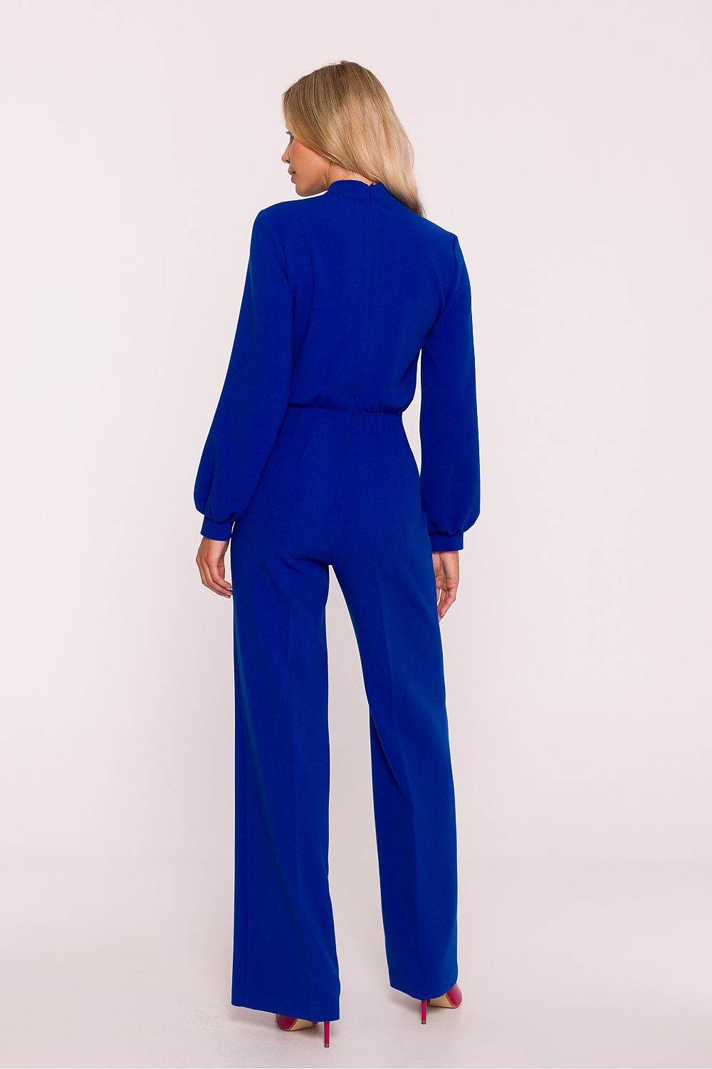 Woman wearing a blue jumpsuit on a white background