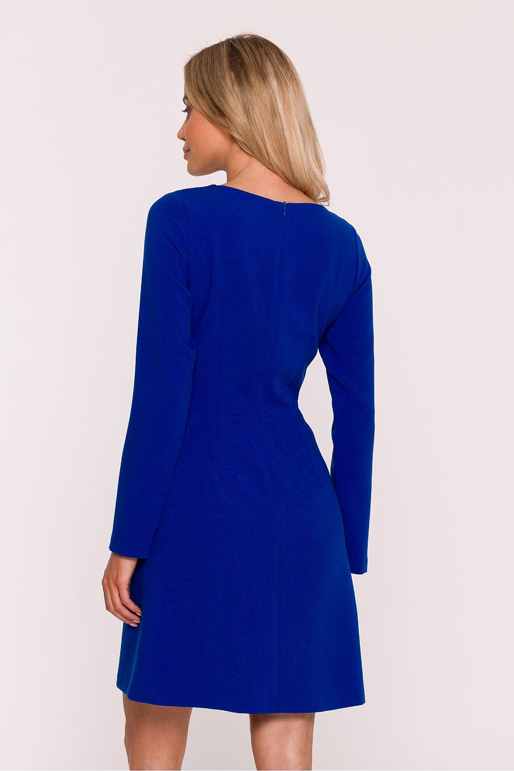 Woman wearing a blue dress with long sleeves on a white background