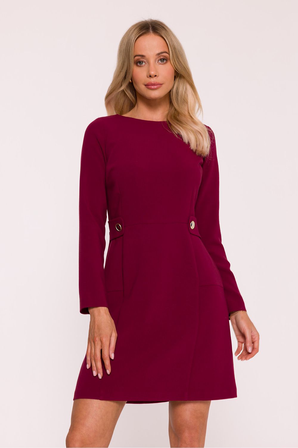 Woman wearing a burgundy dress with long sleeves on a white background