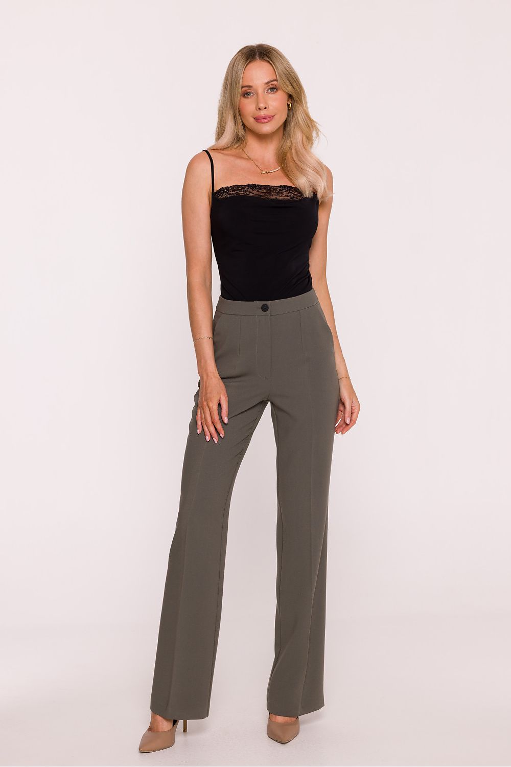 Woman wearing a black top and gray pants on a white background