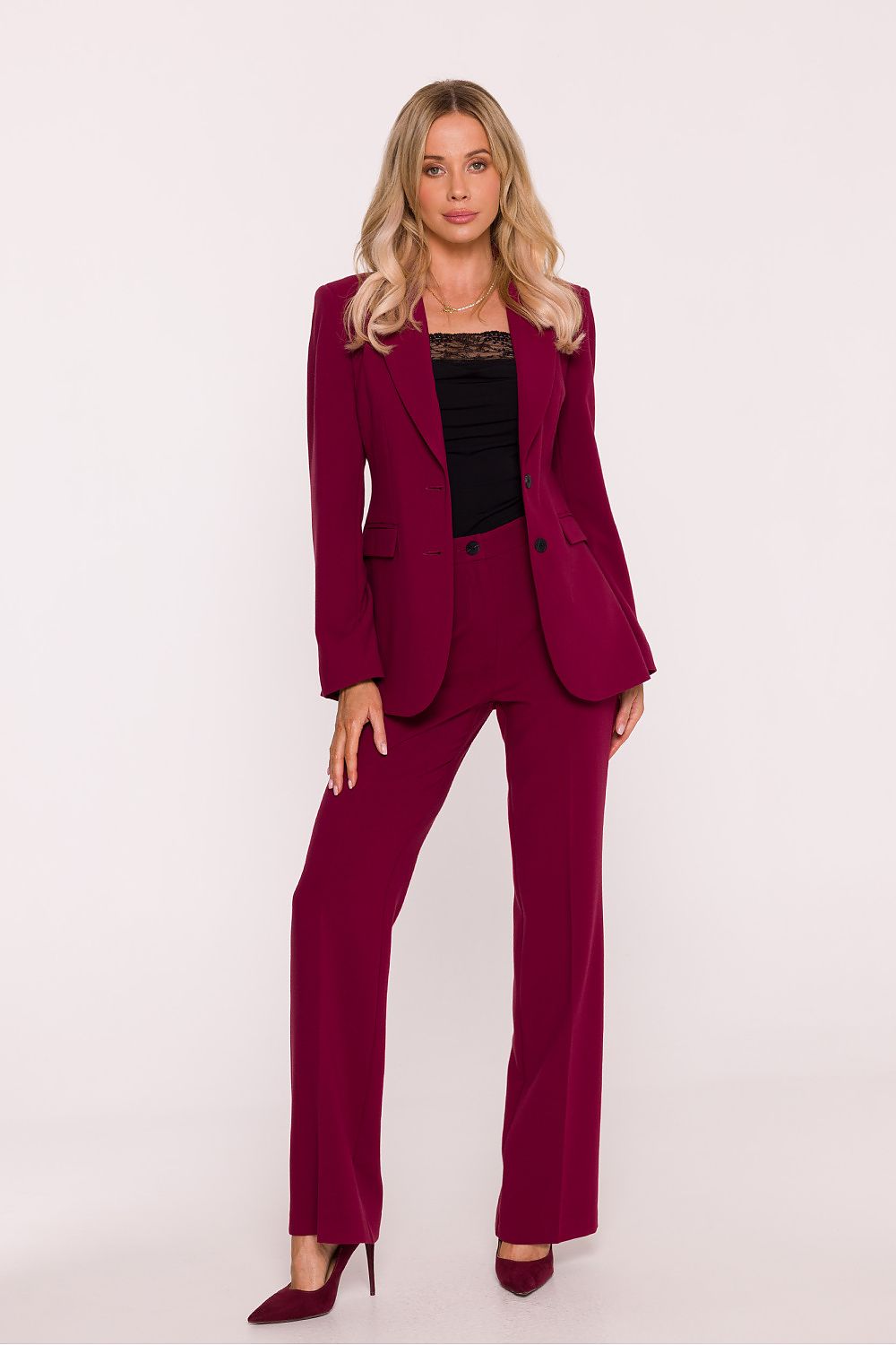 Woman wearing a burgundy suit with a black top on a white background