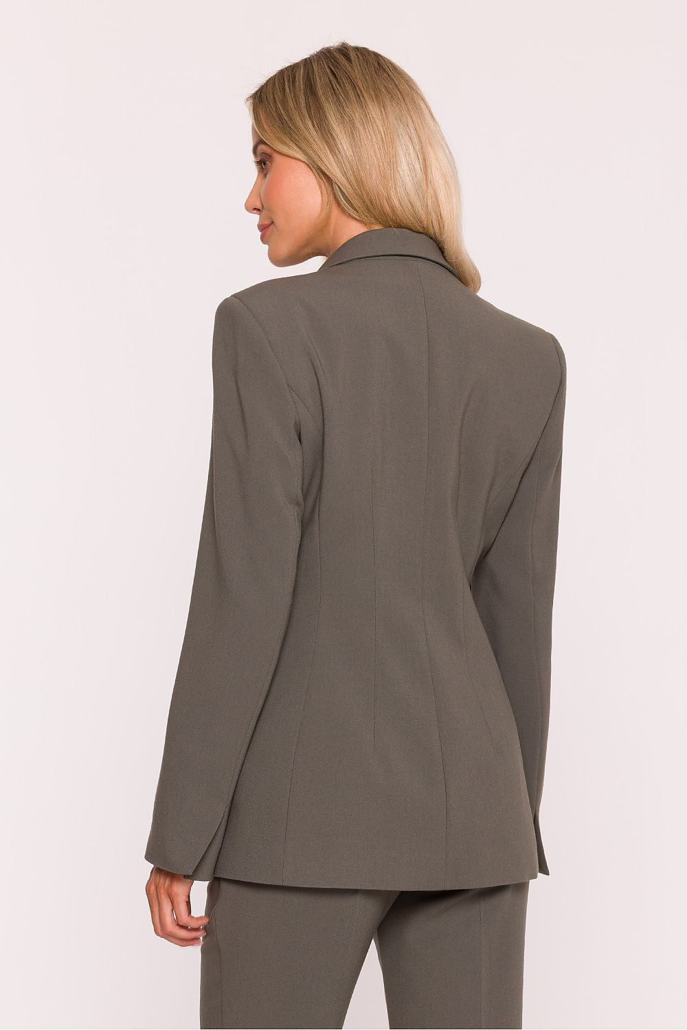 Woman wearing a gray blazer and pants on a white background
