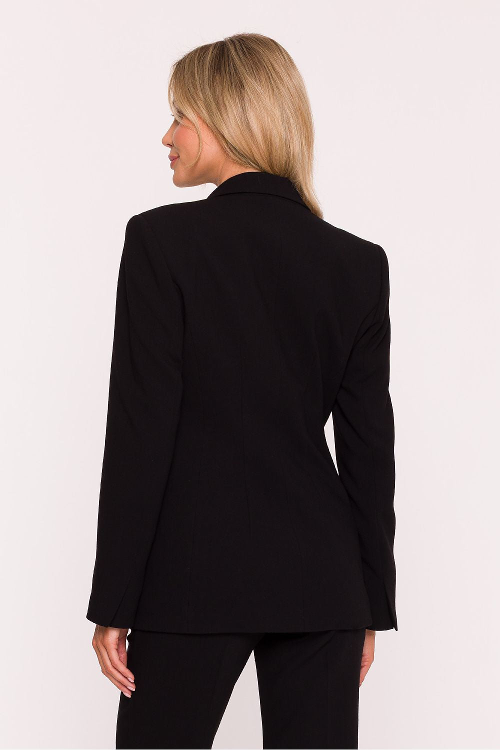 Woman wearing a black suit jacket on a white background