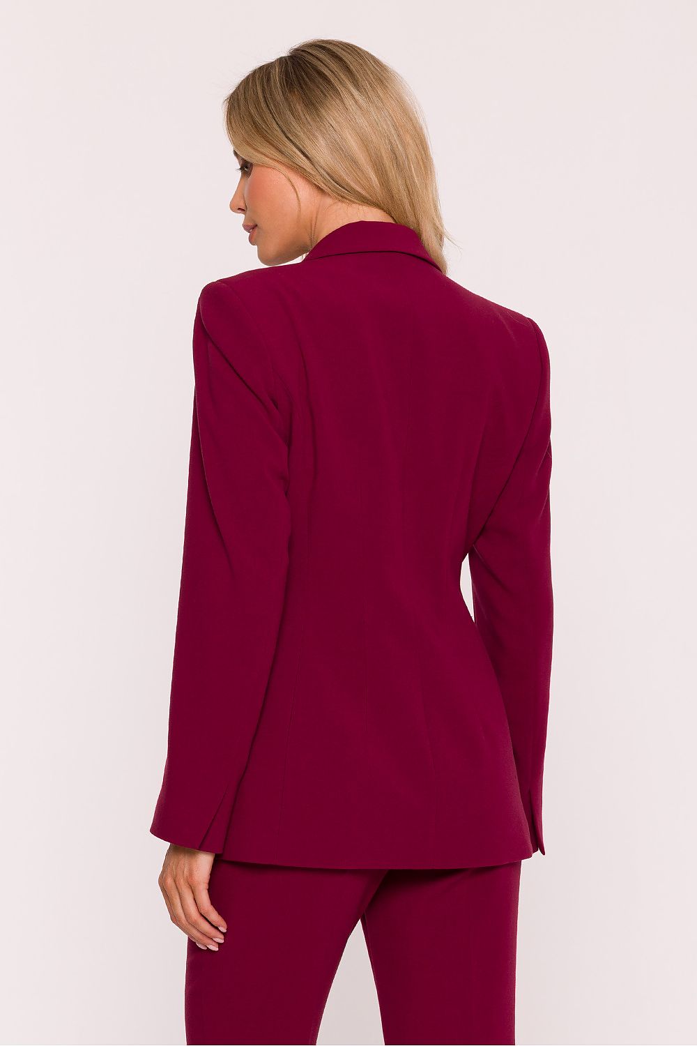 Woman wearing a burgundy suit on a white background