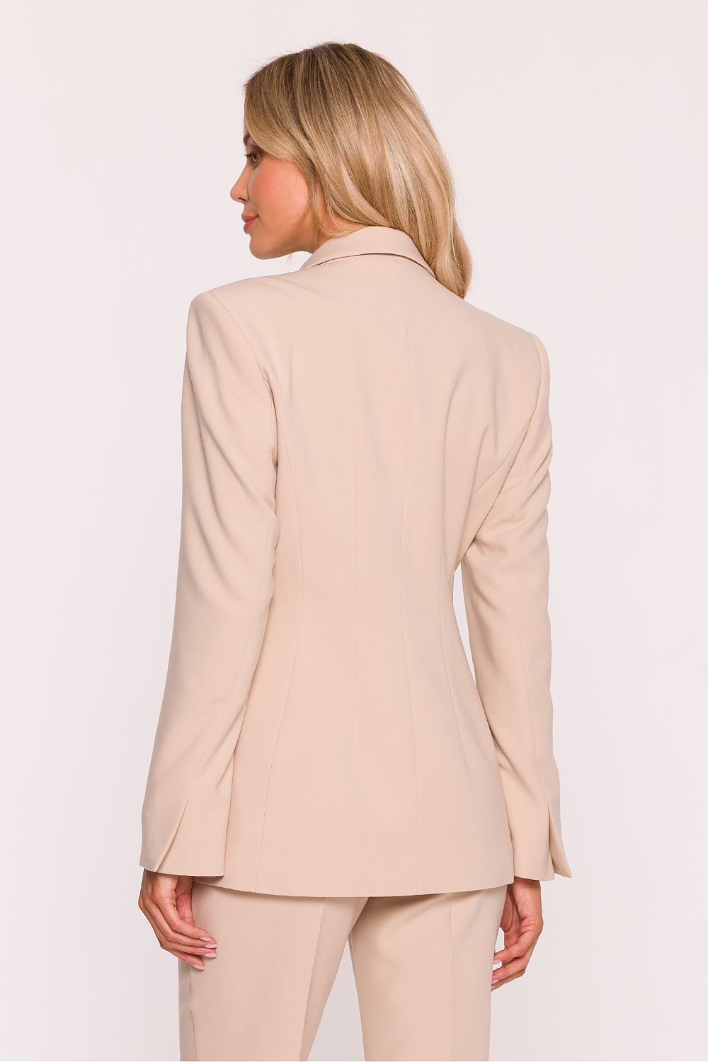 Woman wearing a beige suit on a white background
