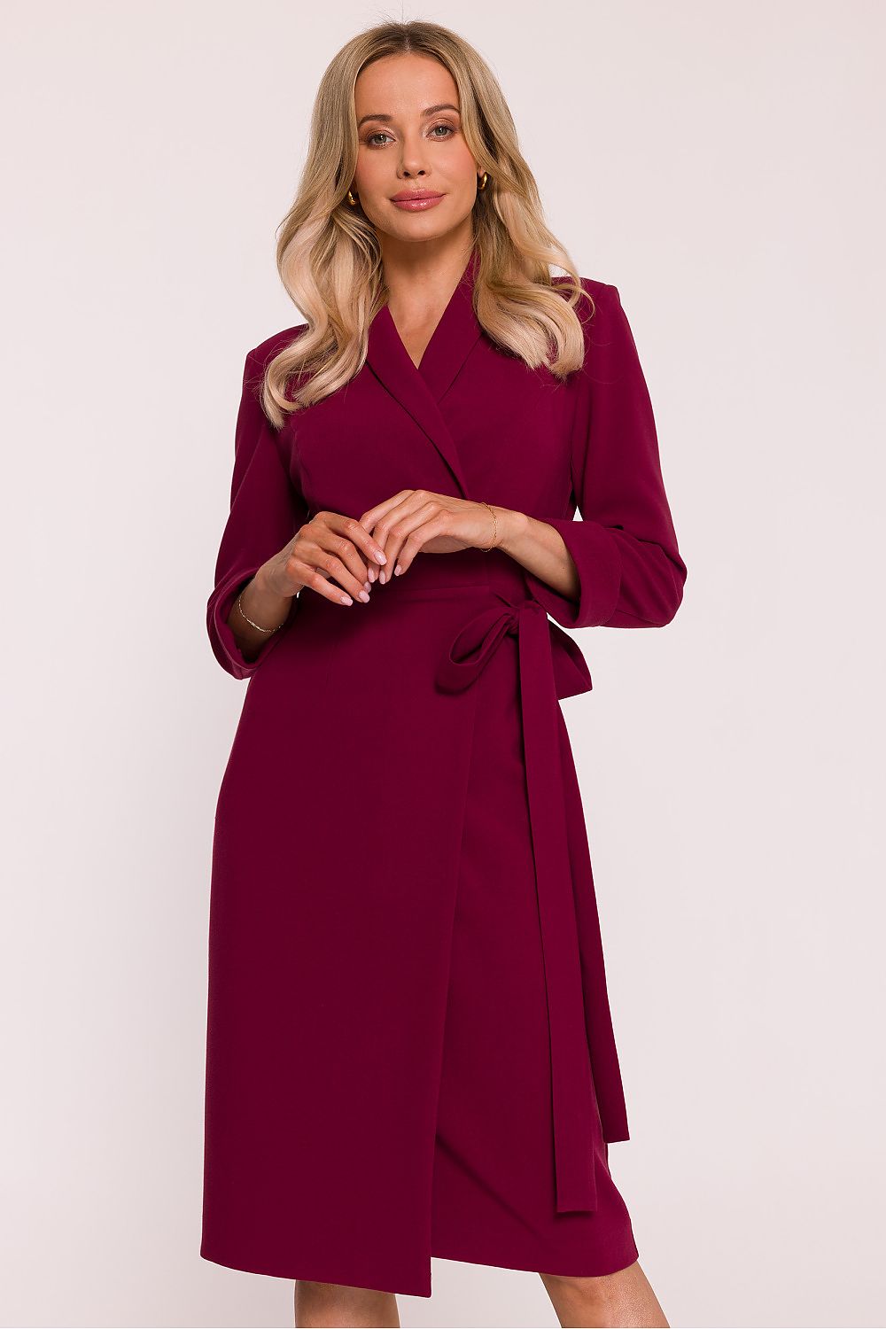 Woman wearing a burgundy wrap dress against a white background