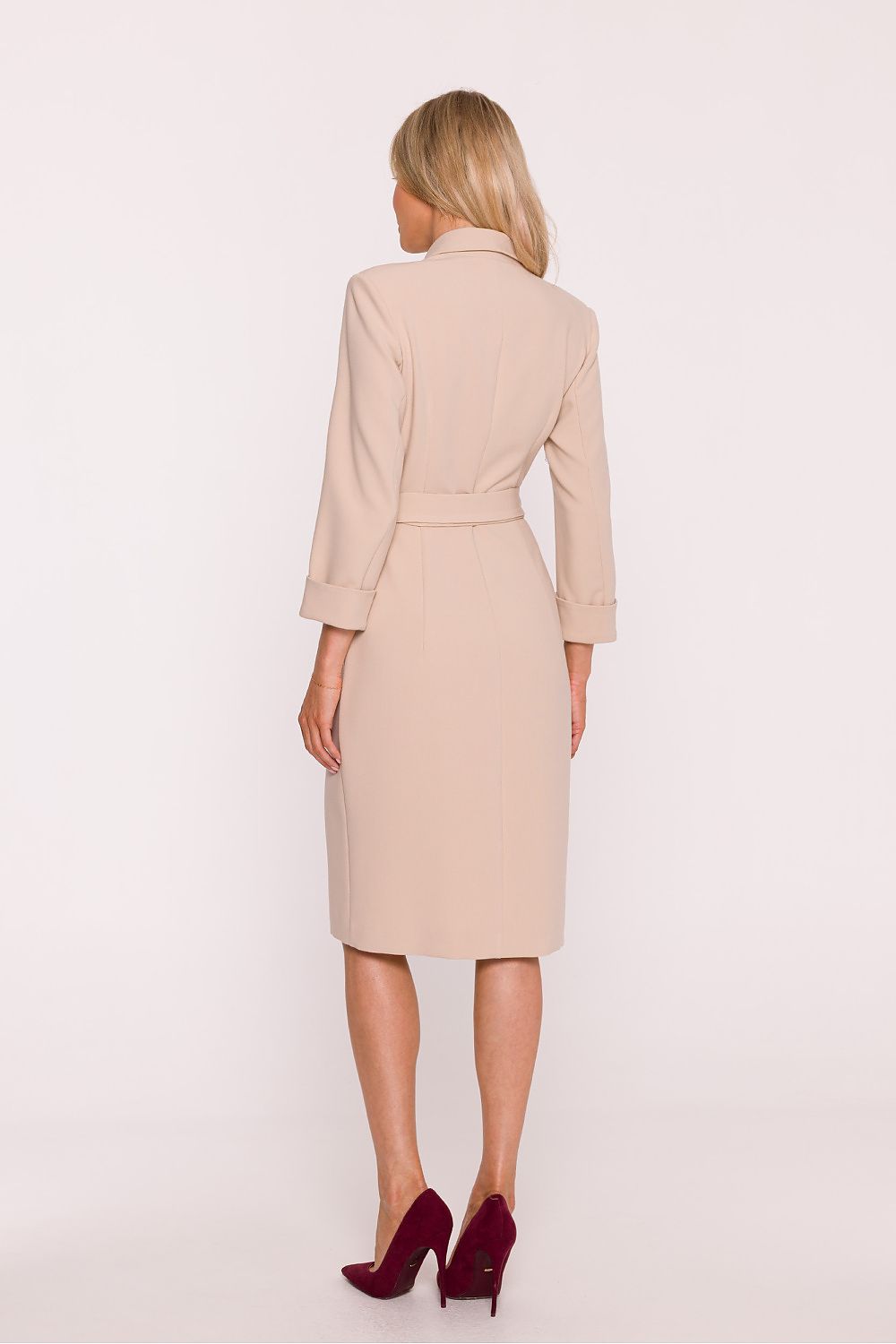 Woman wearing a beige coat on a white background