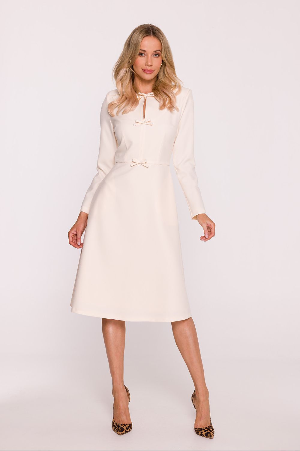 Woman wearing a white dress on a plain background