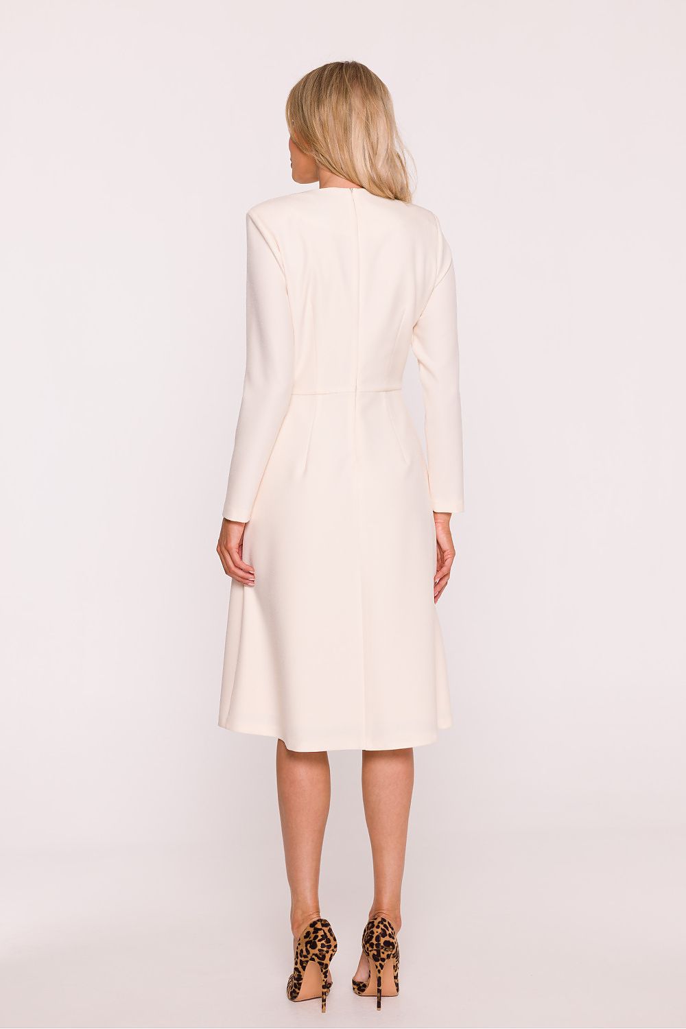 Woman wearing a white dress on a plain background