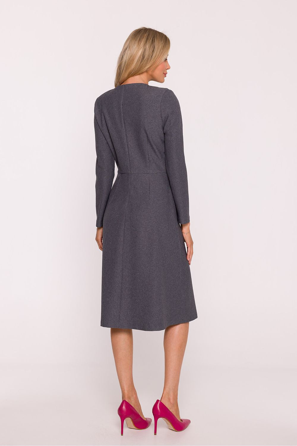 Woman wearing a gray dress with a belt on a white background