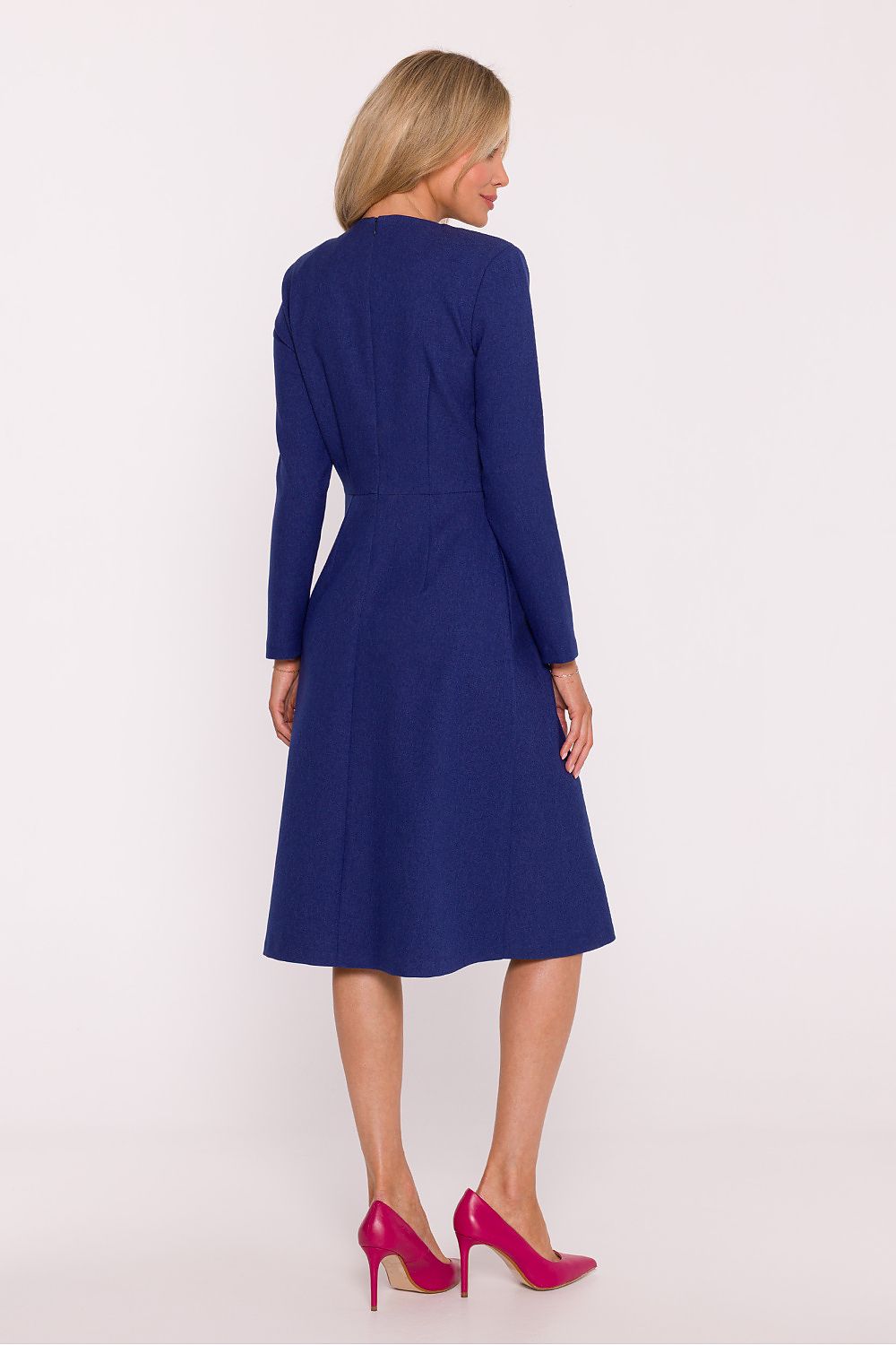 Woman wearing a blue dress with long sleeves on a white background