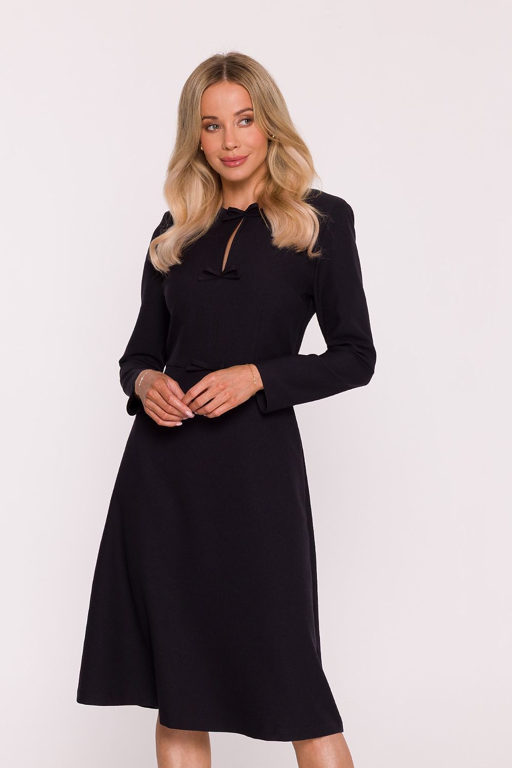 Woman wearing a black dress against a white background