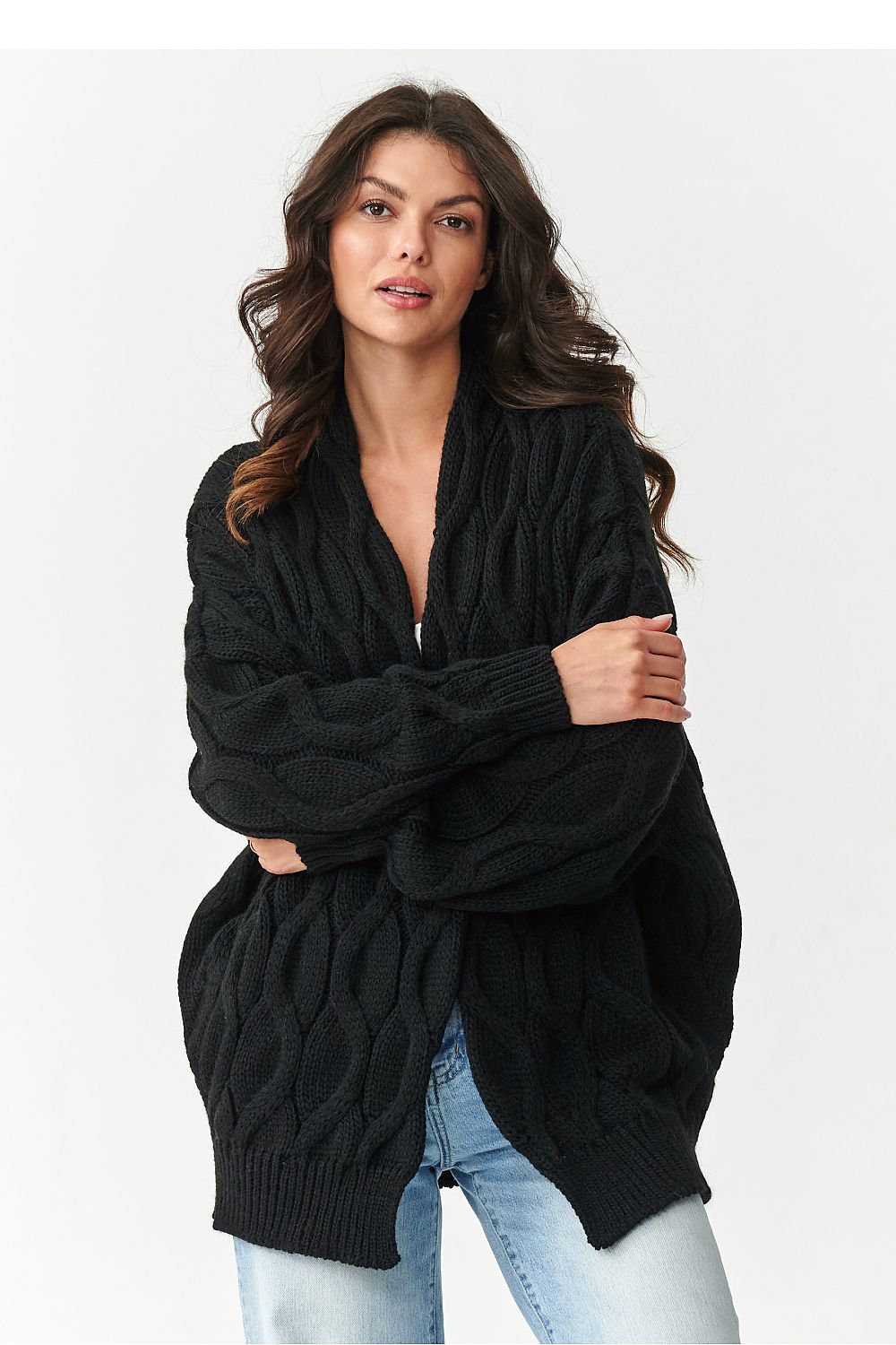 Woman wearing a black cable knit cardigan on a white background
