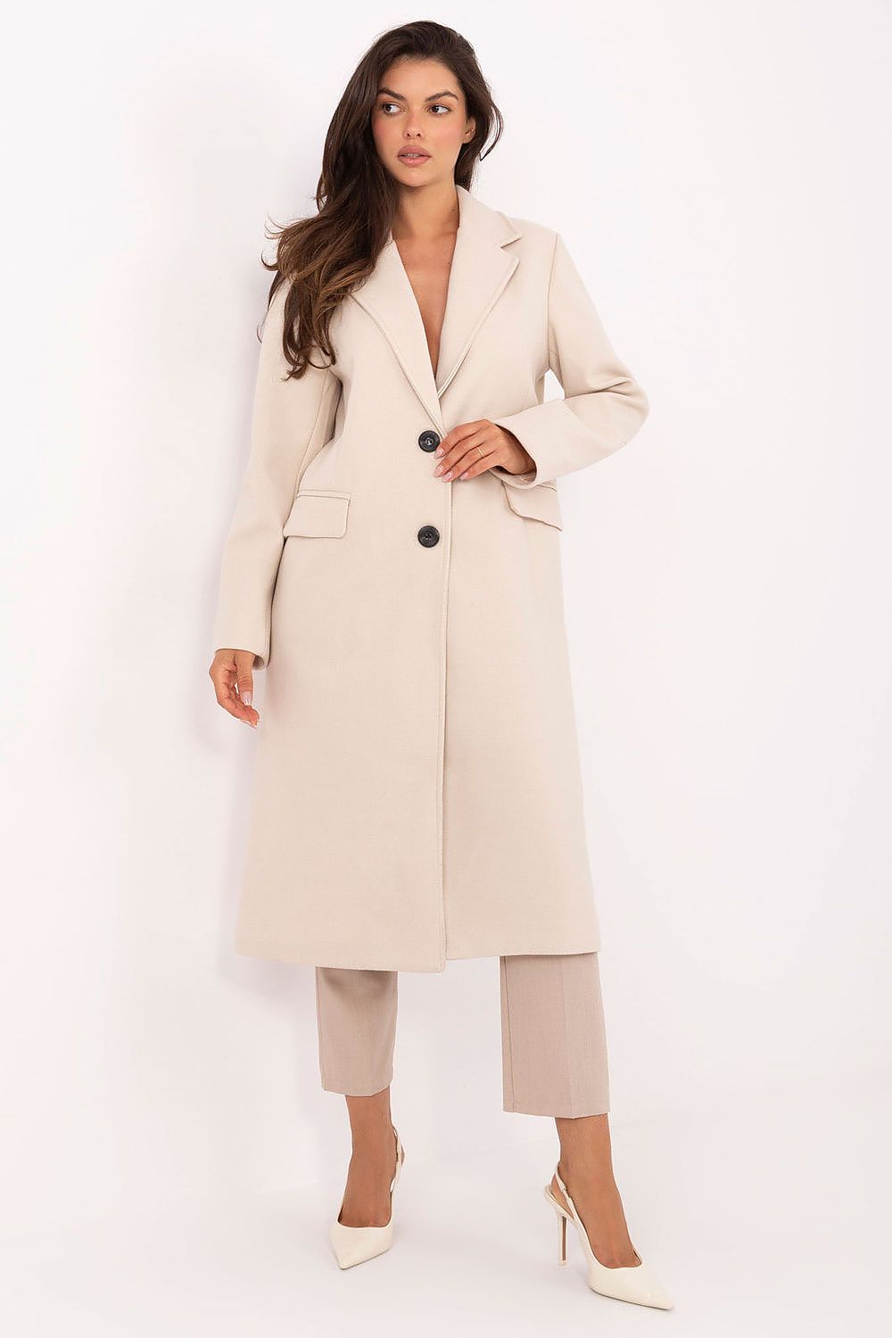 Woman wearing a beige coat with black buttons on a white background