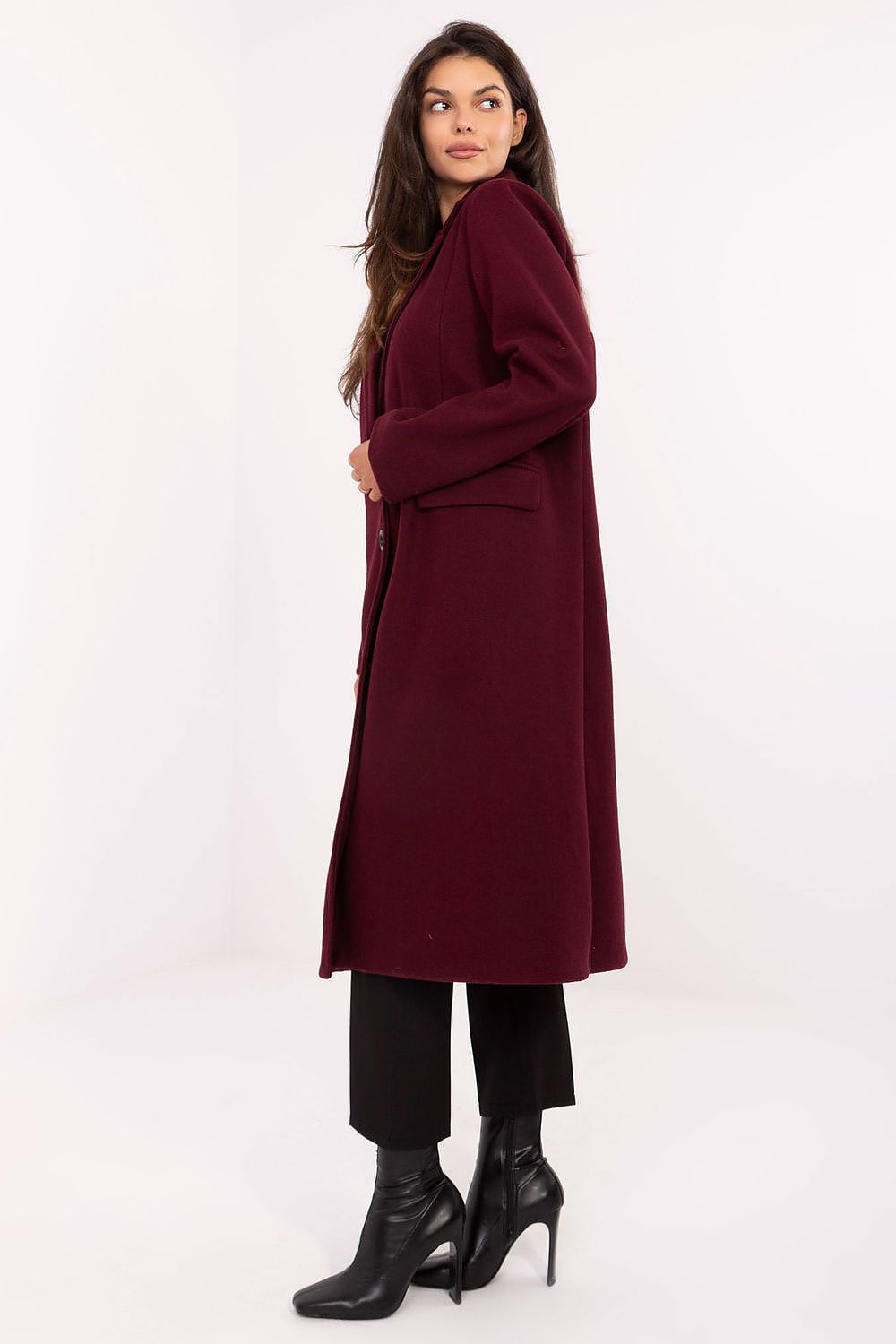 Woman wearing a burgundy coat on a white background
