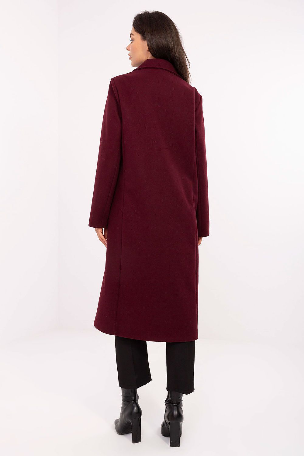 Woman wearing a burgundy coat on a white background