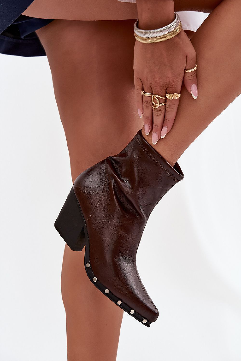 Side view showing decorative studs on sole and zipper closure in brown eco leather.