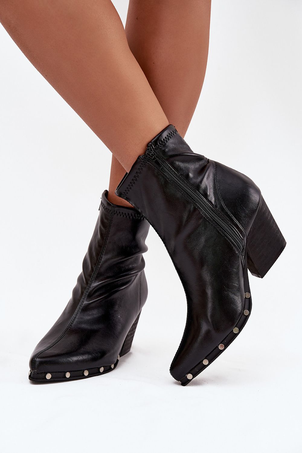  Side view showing zipper fastening and studded sole detail on black cowboy boots.