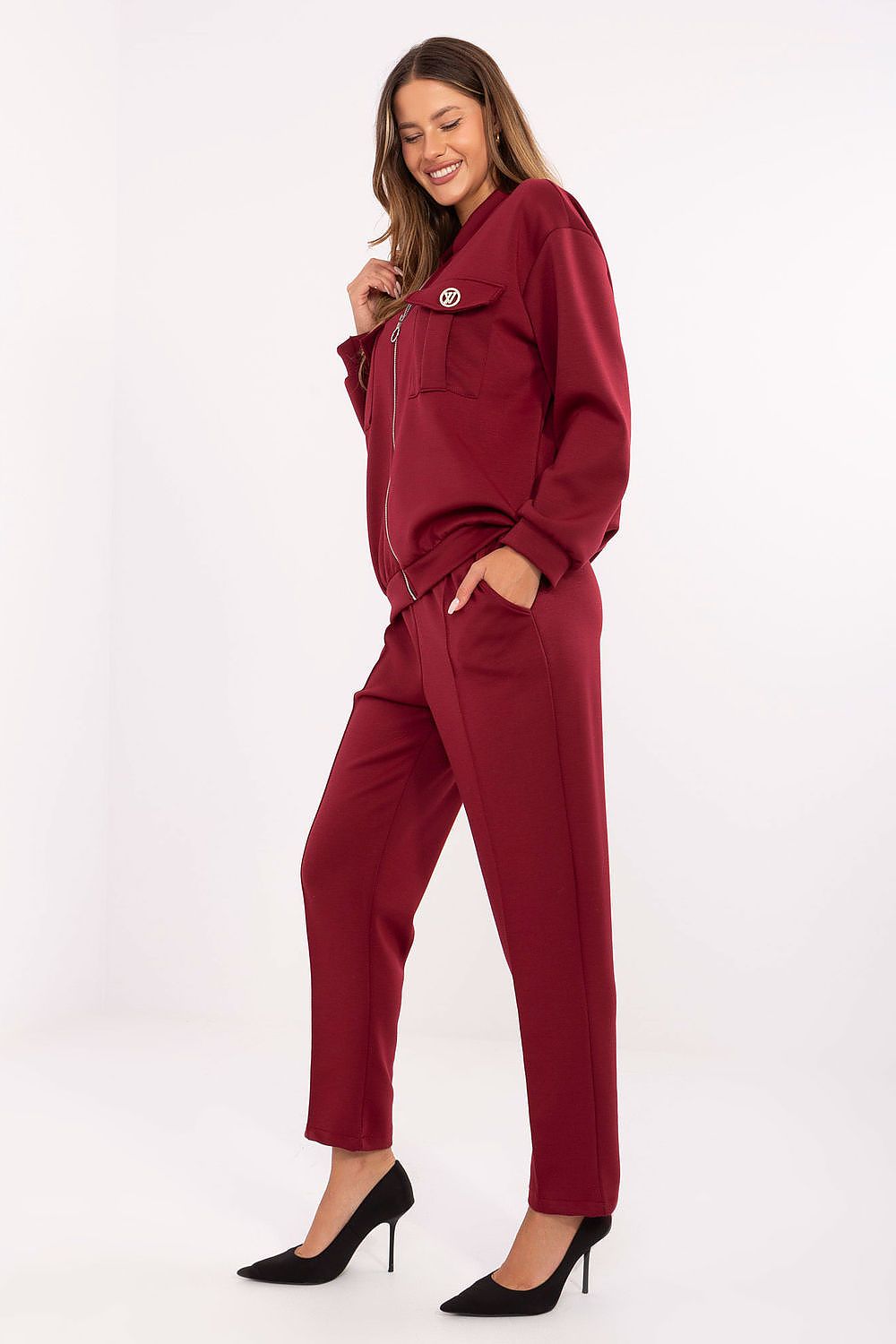Side view highlighting high-waisted tapered pants with decorative belt and side slip pockets.