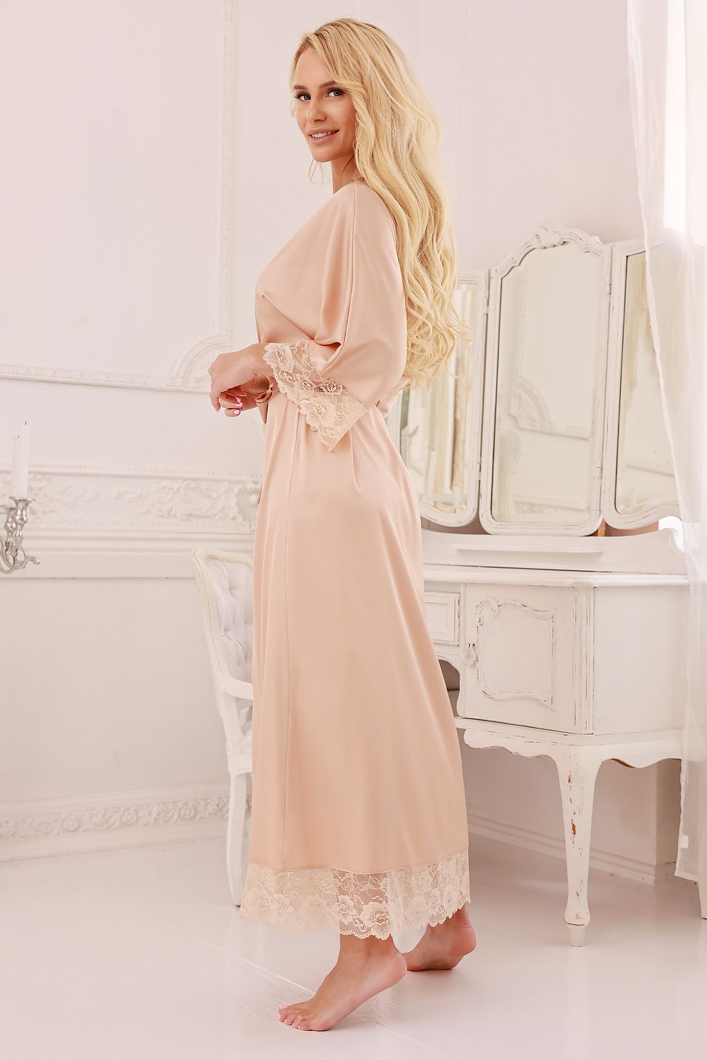 Beige satin gown displayed on hanger with flowing silhouette and waist belt 