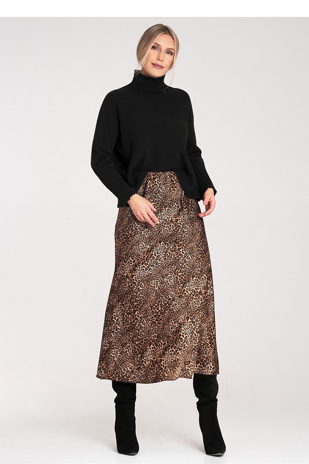 Woman wearing a black turtleneck and leopard print skirt on a white background