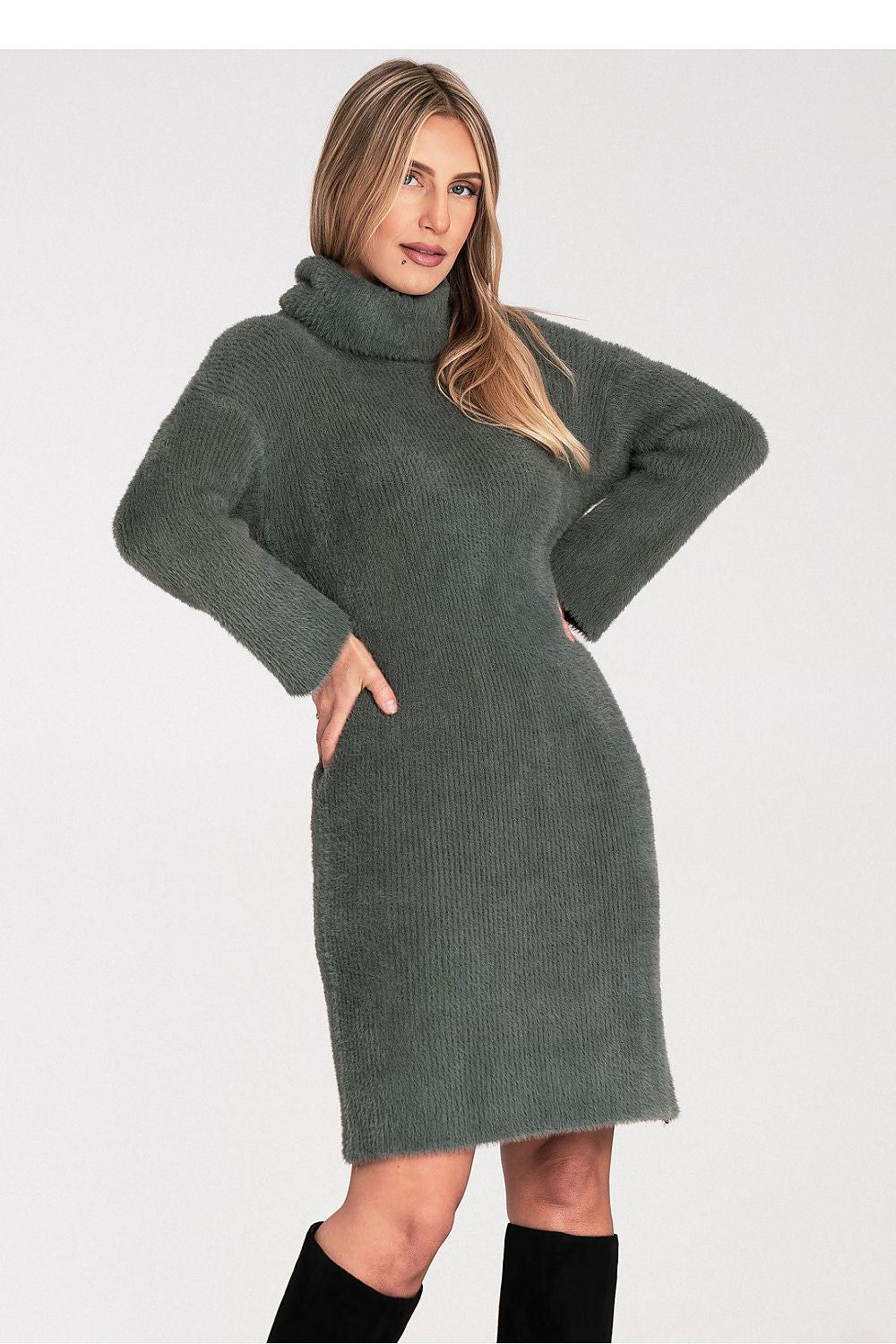 Woman wearing a green knitted dress on a white background