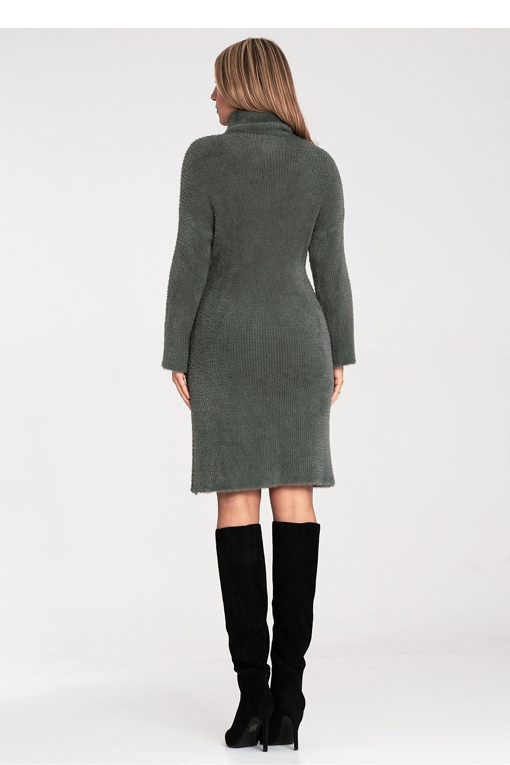 Woman wearing a green dress with long sleeves on a white background