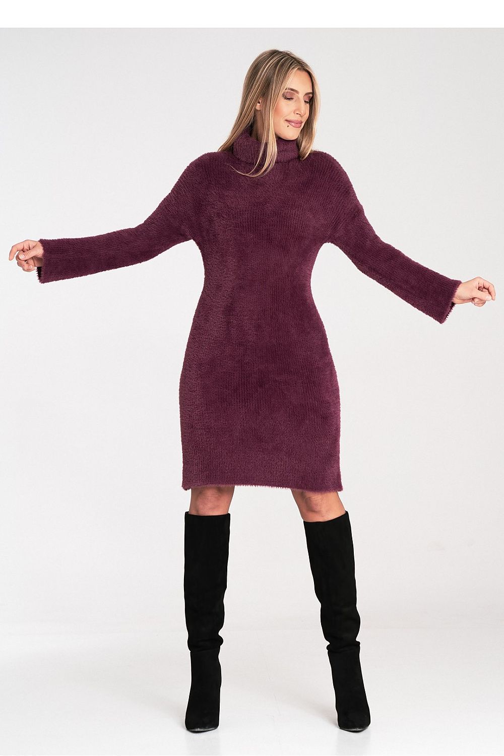 Woman wearing a purple dress with a high collar and black knee-high boots on a white background