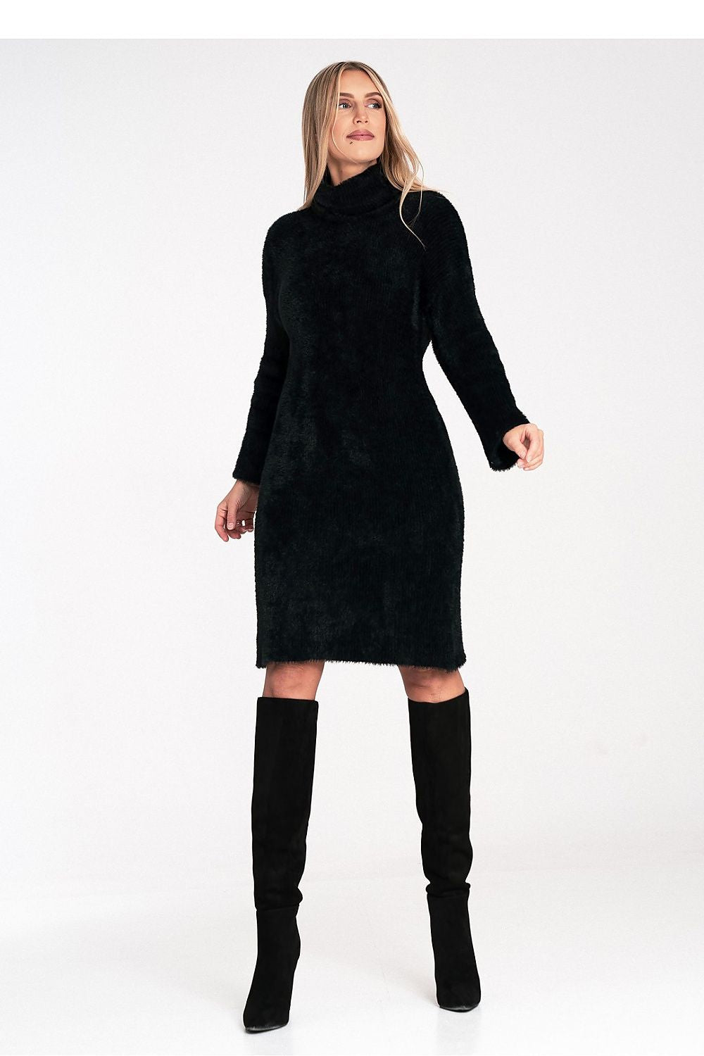 Woman wearing a black dress and knee-high boots on a white background