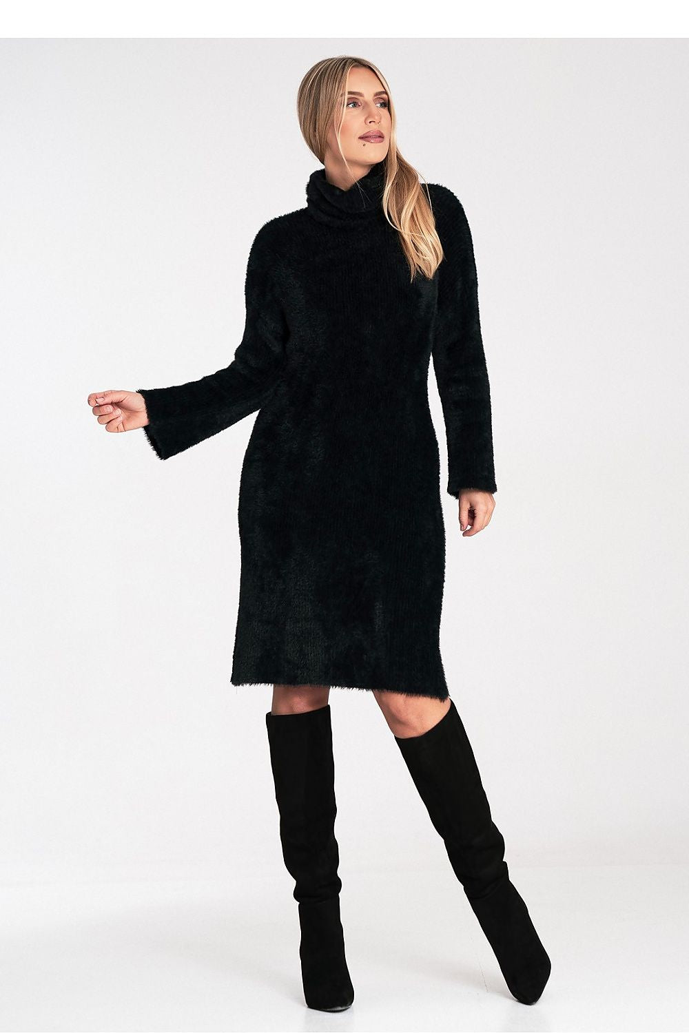 Woman wearing a black dress and knee-high boots on a white background