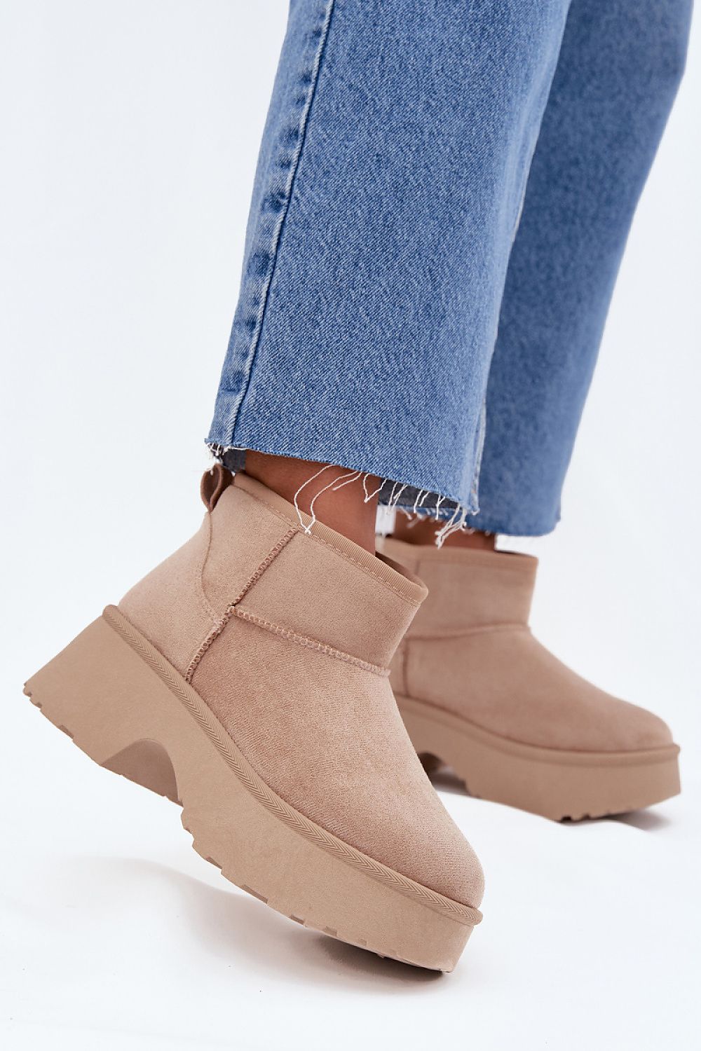 Side profile of slip-on faux suede snow boots highlighting warm lining and design.