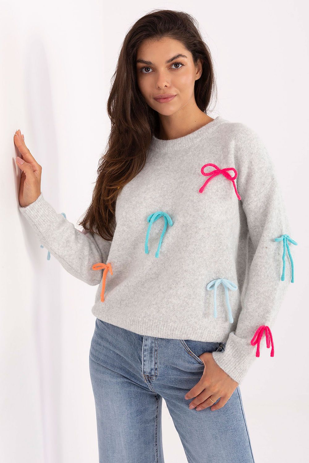 Grey women’s sweater with long sleeves and colorful bows, front view.
