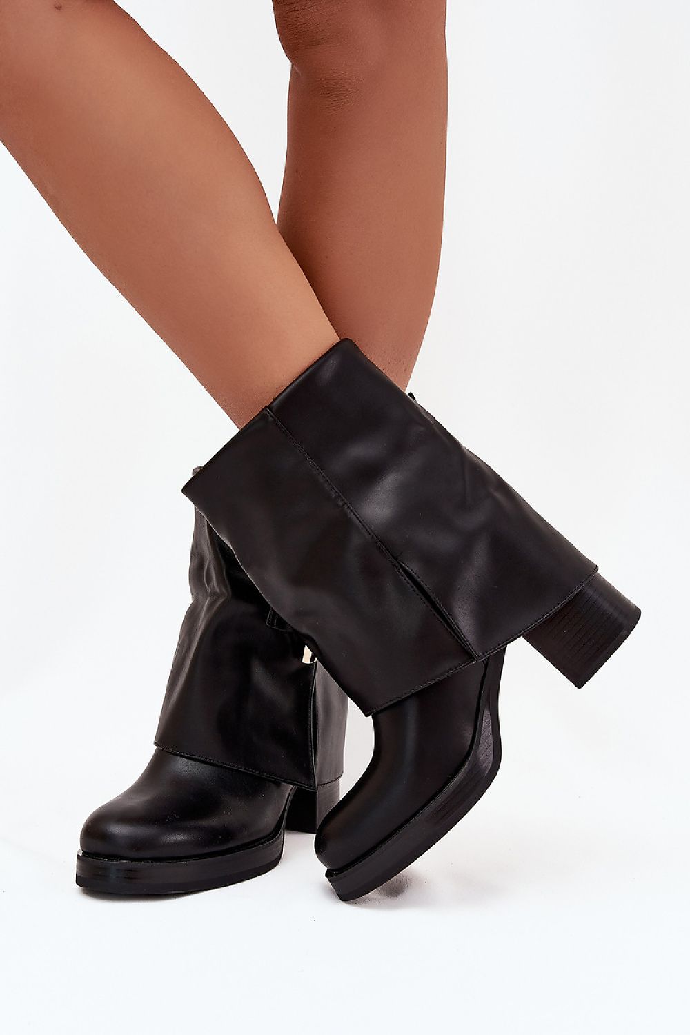 Side view highlighting rounded toe, slip-on style, and chic buckle of black Liora boots.