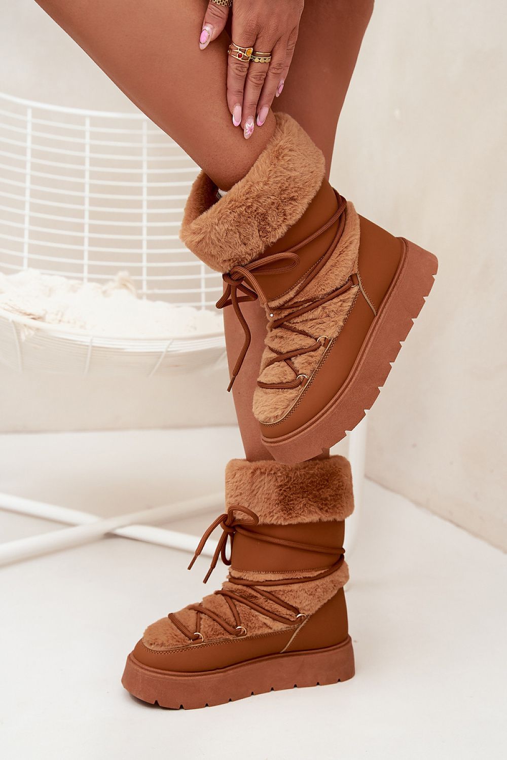 Side view of brown eco leather snow boots with platform sole and warm fur trim